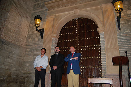 El  párroco David Ruiz, junto a Manuel García y José Manuel Cano, ante la puerta de  Santa Catalina